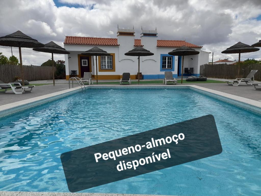 a swimming pool with a sign in front of a house at Casas da Minh'Alma in Reguengos de Monsaraz