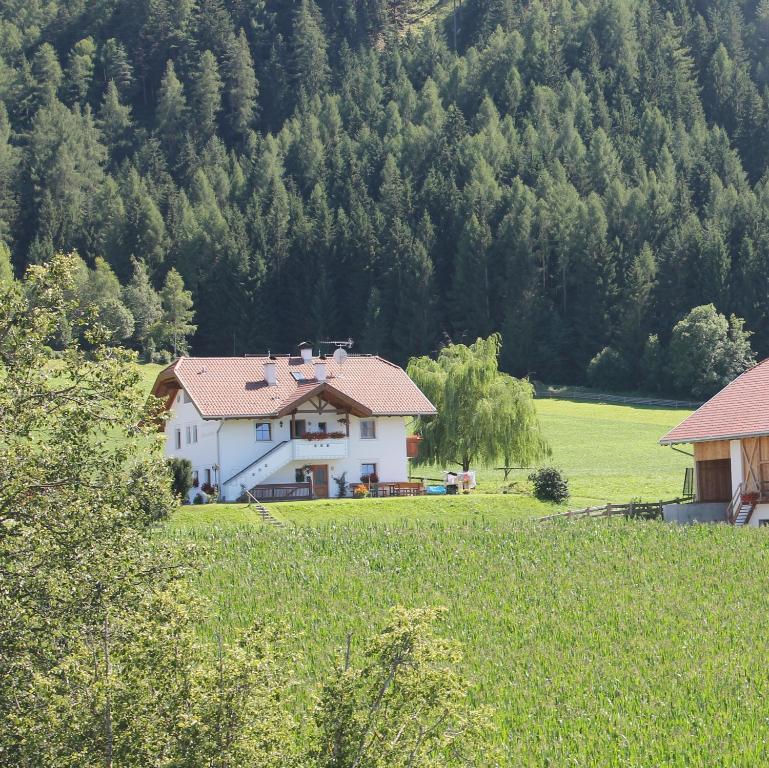 una casa blanca en medio de un campo en Beikircherhof, en San Lorenzo di Sebato