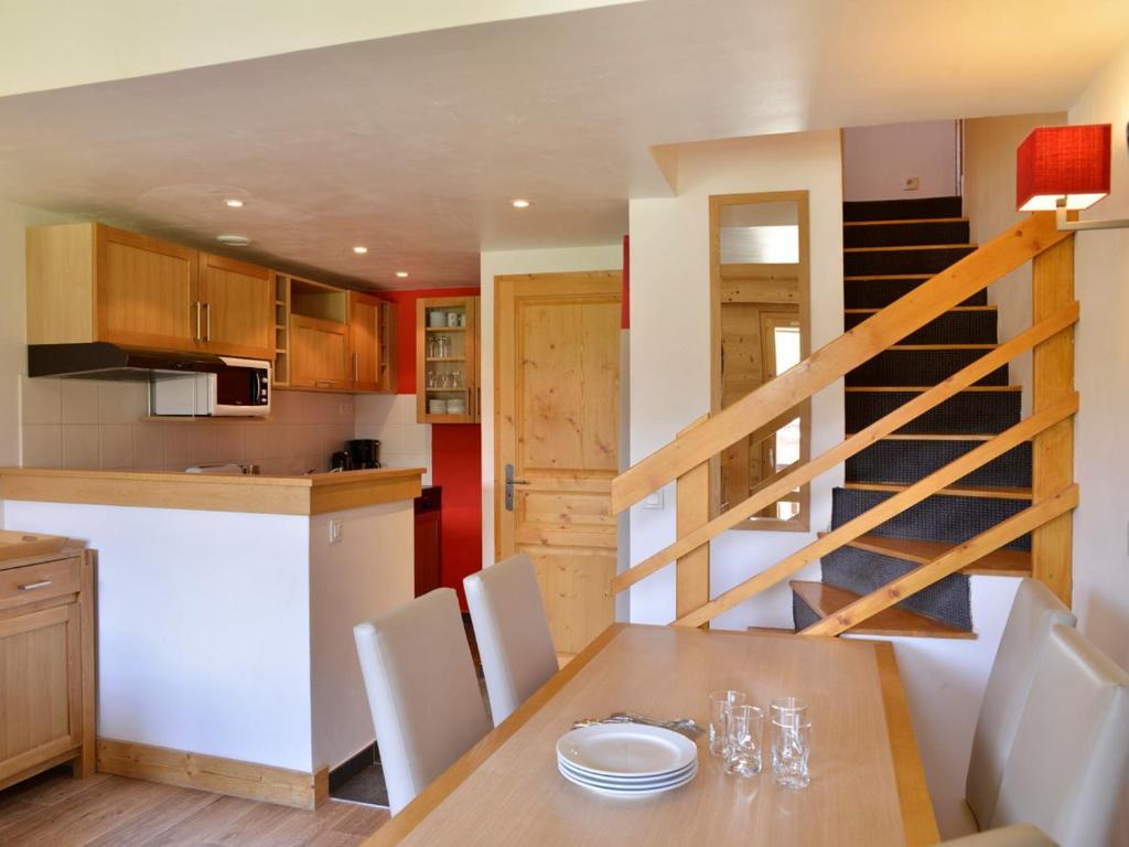 une cuisine et une salle à manger avec une table et un escalier dans l'établissement Appartement duplex 6 pers · Ski aux pieds · Piscine chauffée · Animaux admis - FR-1-181-2805, à La Plagne Tarentaise
