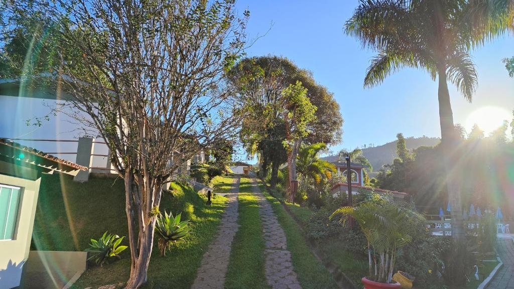 um jardim com palmeiras e um passadiço em Chalés Vila da Serra em Serra Negra
