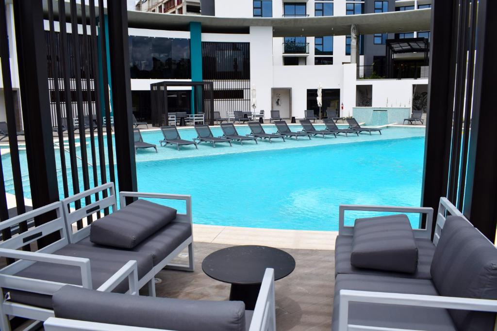 a swimming pool with lounge chairs and a table at Apartamento con piscina y espacio de trabajo in San José