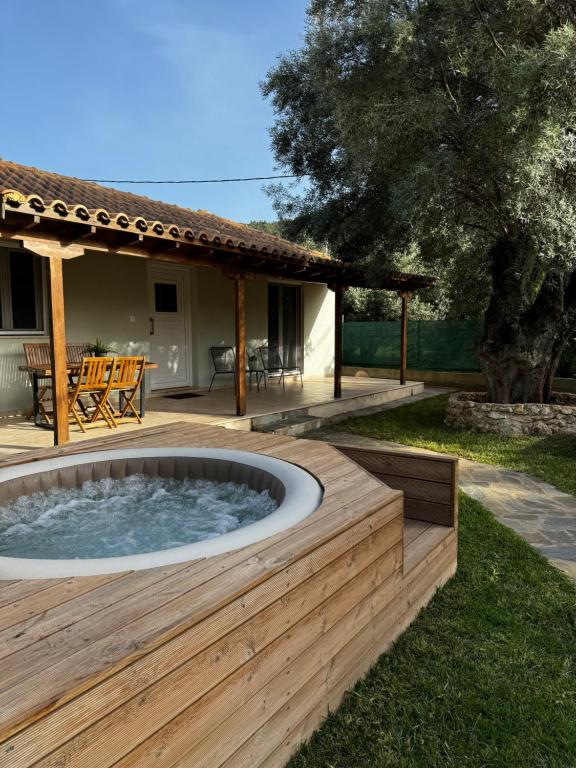 un patio con bañera de hidromasaje en una terraza de madera en Elleria's House en Lefkada