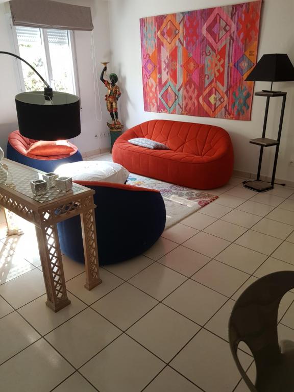 a living room with a couch and a table at Appartement avec jardin in Eysines