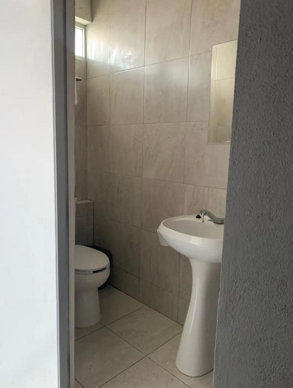 een witte badkamer met een toilet en een wastafel bij Front vista in Aguascalientes