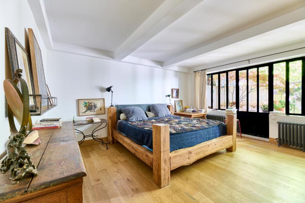 a bedroom with a large bed and a table at Très beau Loft Industriel Paris 20e in Paris