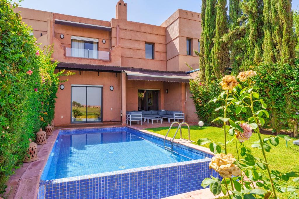 a house with a swimming pool in front of a yard at Summer Villa Peaceful Golf Haven in Marrakech