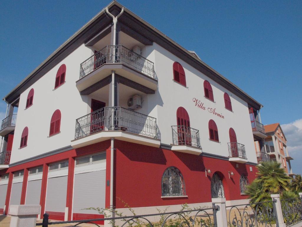 un edificio rojo y blanco con una torre en él en Villa Armin, en Rovinj