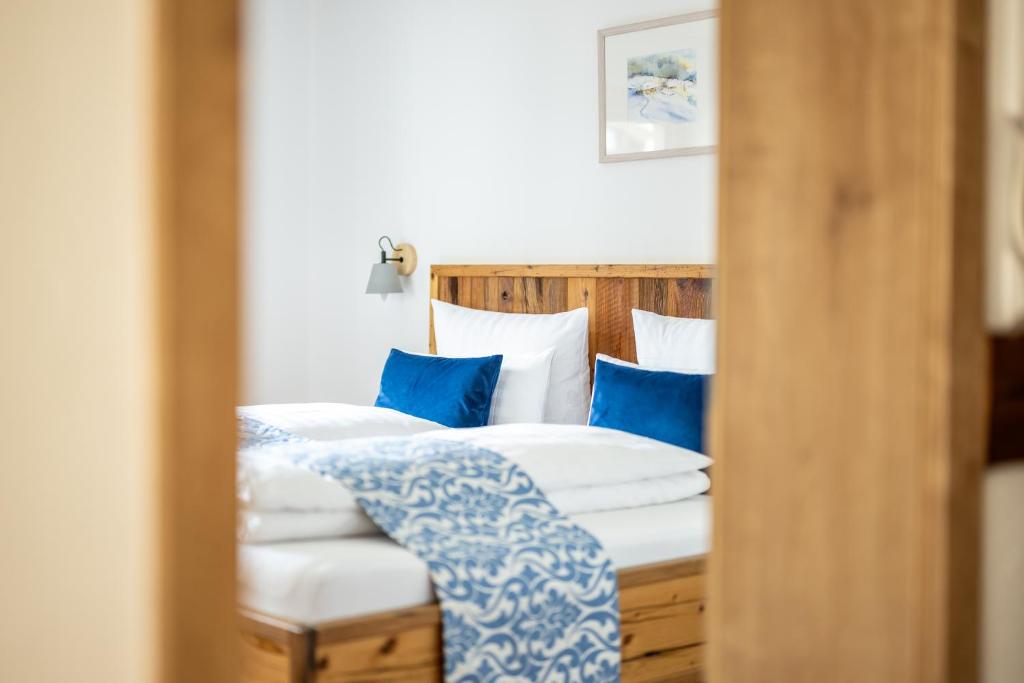 a reflection of a bed with blue pillows in a mirror at Haus Tannberg in Riezlern