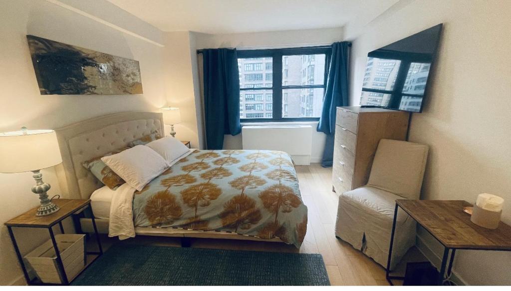 a bedroom with a bed and a table and a chair at Unique Place in midtown NYC in New York
