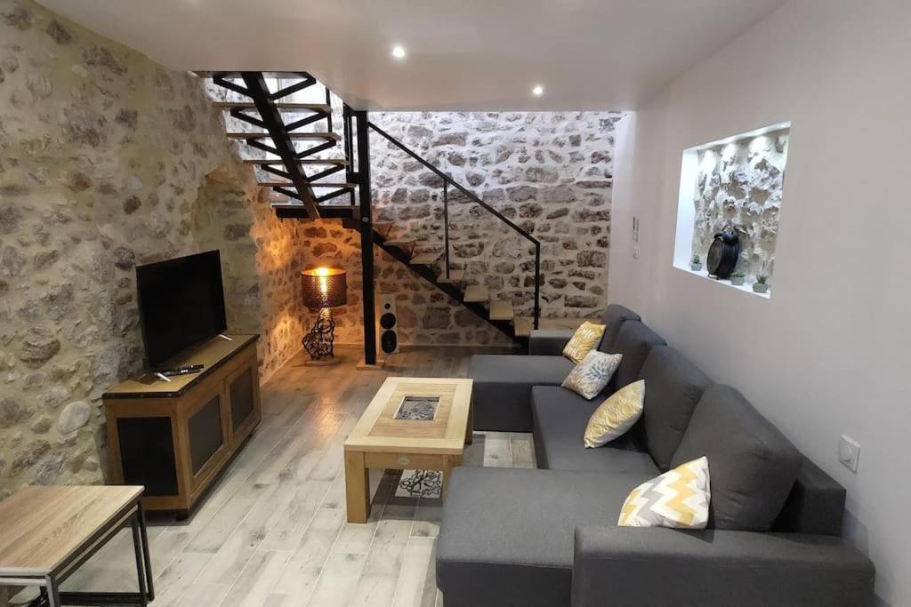 a living room with a couch and a tv at La Romarine in Chauzon