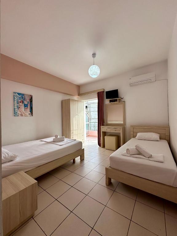 a hotel room with two beds and a tv at Elysian Sunset Studios in Himare