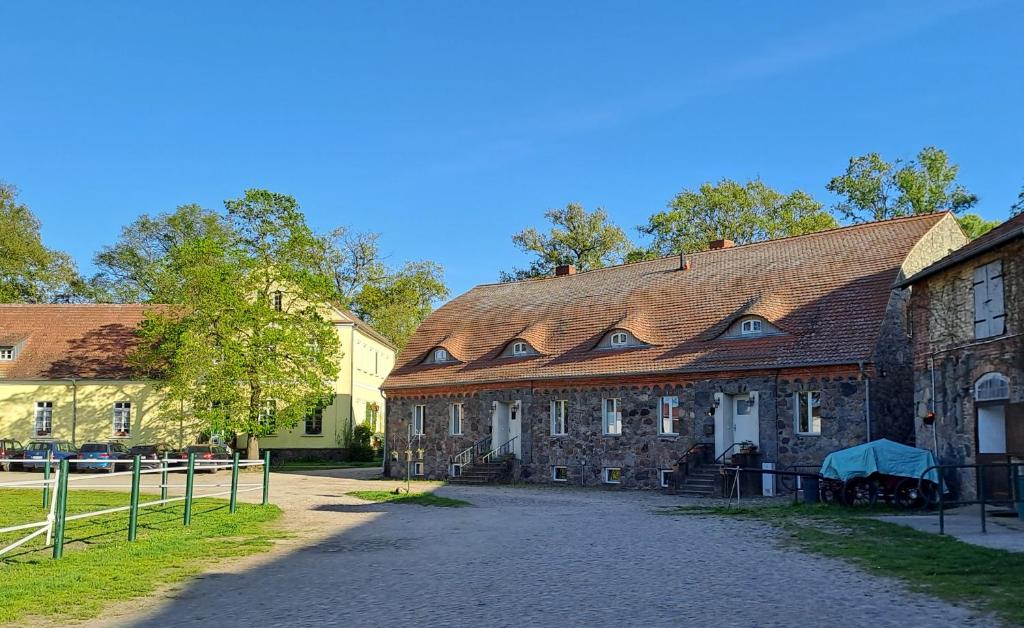 Un gran edificio de piedra con techo rojo. en Inspektorhaus-Behlendorf, en Steinhöfel