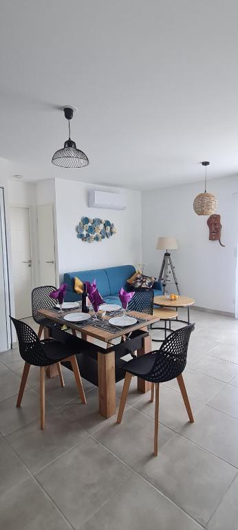 ナルボンヌ・プラージュにあるAppartement SUNSET LODGEの木製のテーブルと椅子のあるリビングルーム
