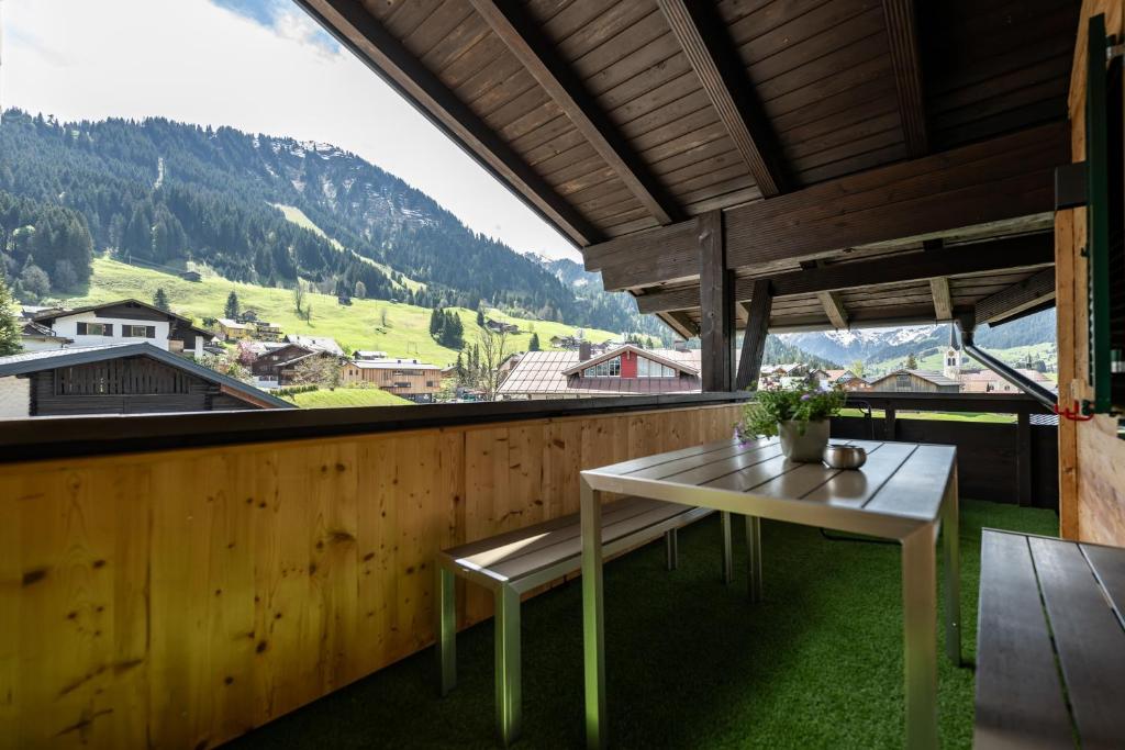 a table on a balcony with a view of a mountain at Haus Tannberg in Riezlern