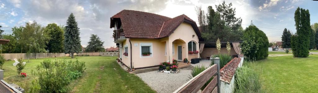 a small house in a yard with a green field at Liliána apartman in Balatonberény