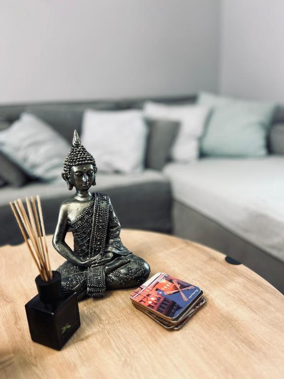 a statue of a buddha sitting on a table at Brand new brilliant apartment at Athenian Riviera in Athens