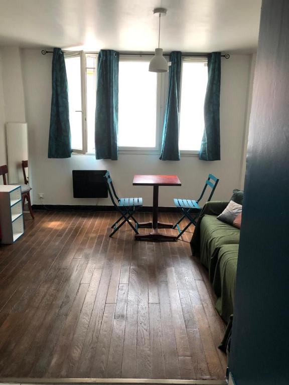 un salon avec une table, des chaises et un canapé dans l'établissement Au coeur du 18eme arrondissement proche de Montmarte et des Jeux Olympiques, à Paris
