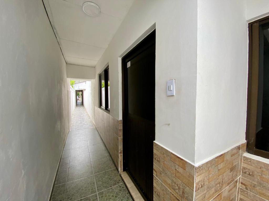 a hallway with a black door and a tile floor at Apartamento cerca del aeropuerto in Cartagena de Indias