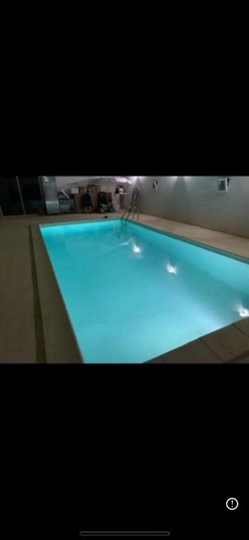 une grande piscine à la lumière bleue dans l'établissement Domaine autour de l’olivier, à Saint-Martin-de-Crau
