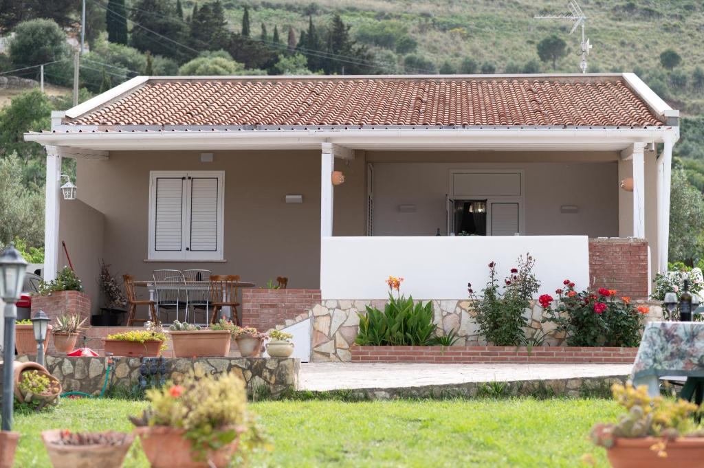 a small house with a white fence in a yard at Villa Mare E Monti in Castellammare del Golfo