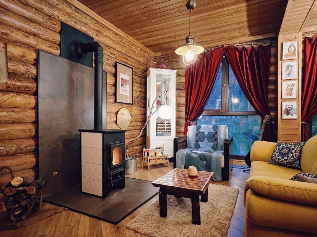 uma sala de estar com lareira num chalé de madeira em Sabay Sai Wooden Guesthouse in The National Park em Almaty
