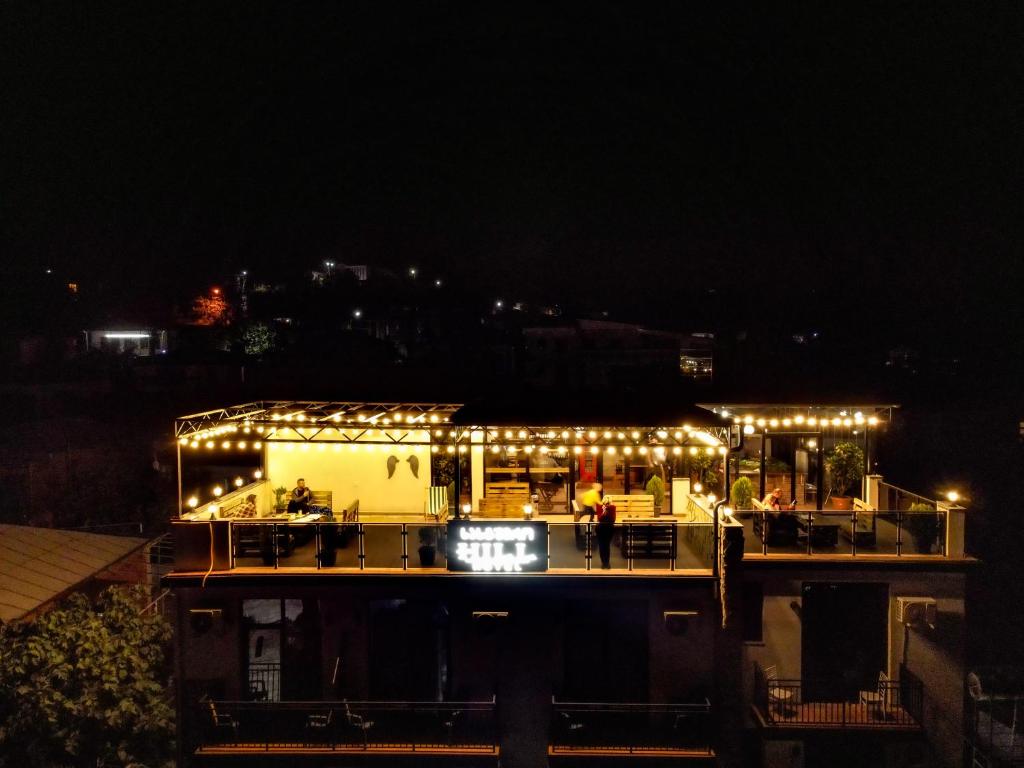 ein Gebäude mit Lichtern in der Nacht in der Unterkunft Hill Hotel in Kutaissi