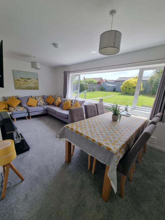 a living room with a table and a couch at The Retreat, Cromer in Cromer