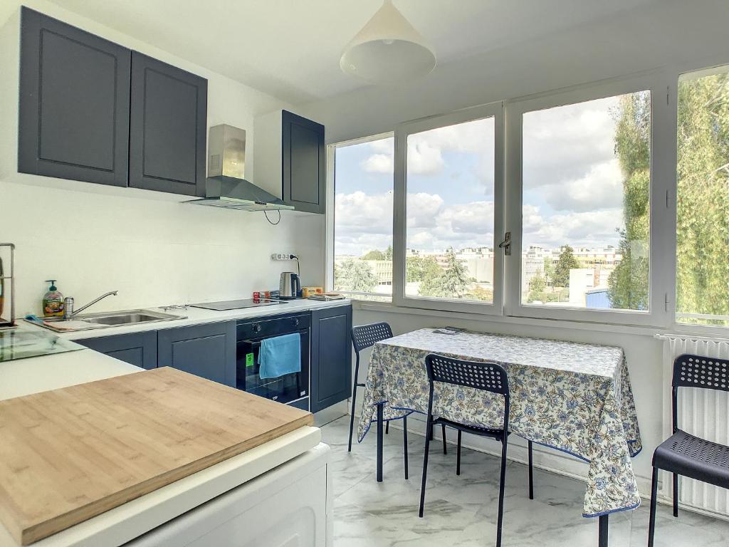 una cucina con tavolo, sedie e finestre di ETS MPRS a Nantes