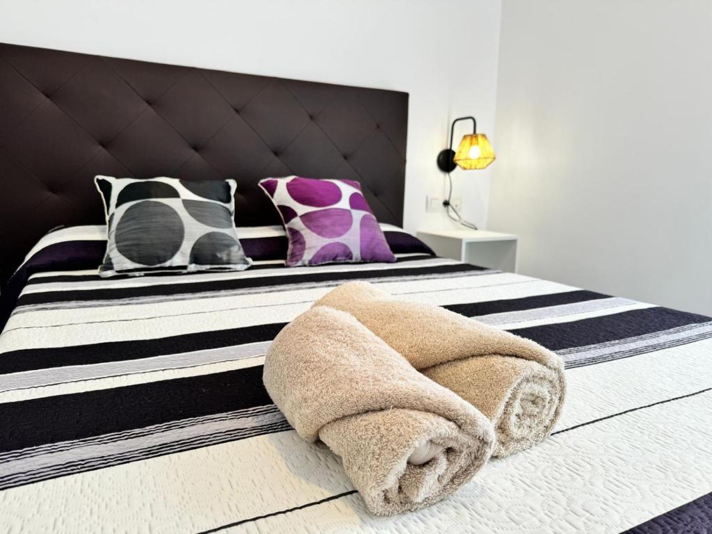 a bedroom with a large bed with black and white stripes at APARTAMENTO ROMELIA 1ºa in Tivenys