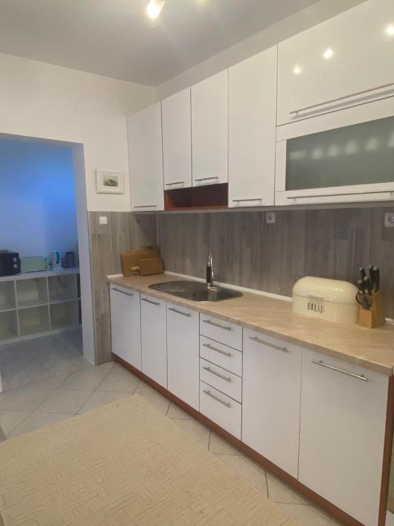 a kitchen with white cabinets and a sink at Apartment Angelina 