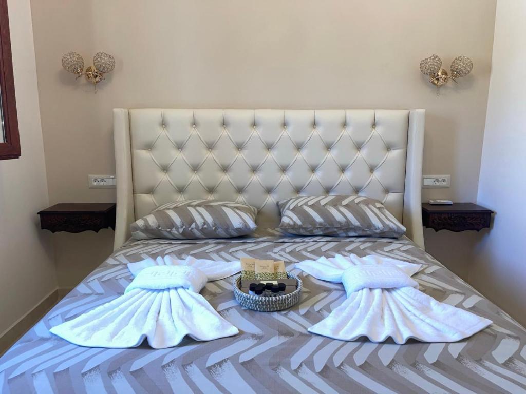 a bed with two pillows and a basket on it at Avra Studios in Lefkos Karpathou