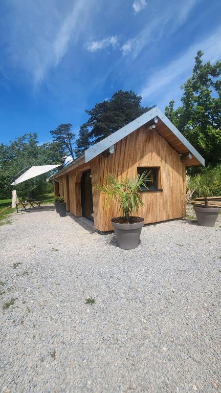 un petit bâtiment avec des plantes en pot devant lui dans l'établissement Lodge du Château de Feschaux, à Villeneuve-sous-Pymont