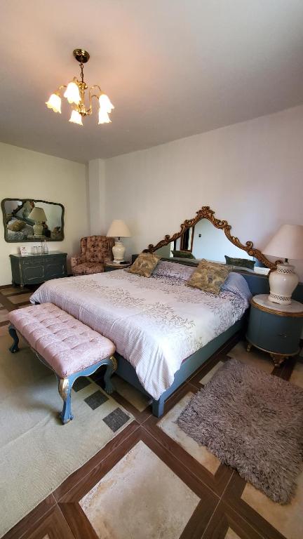 um quarto com uma cama grande e uma cabeceira em madeira em El Monasterio em San Joaquín