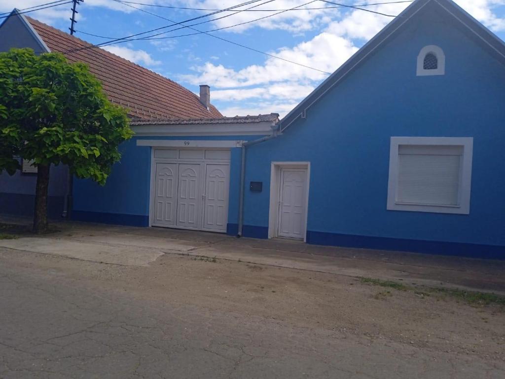 Una casa azul con dos puertas de garaje. en Apartman K 99, Karadjordjeva 99, Bela Crkva en Bela Crkva
