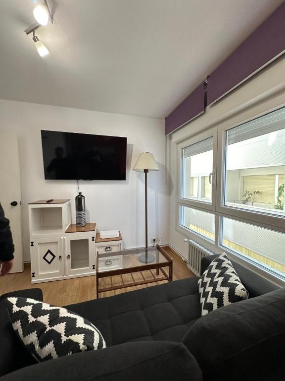 a living room with a couch and a flat screen tv at Piso da Ulla in A Estrada