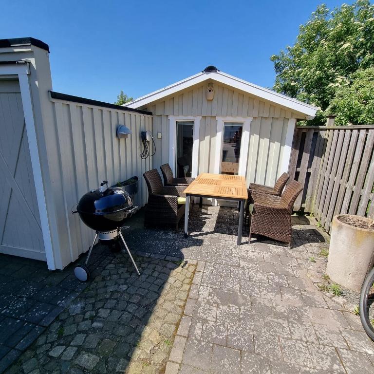 a backyard with a grill and a table and chairs at Strandnära boende, Strandbaden in Falkenberg