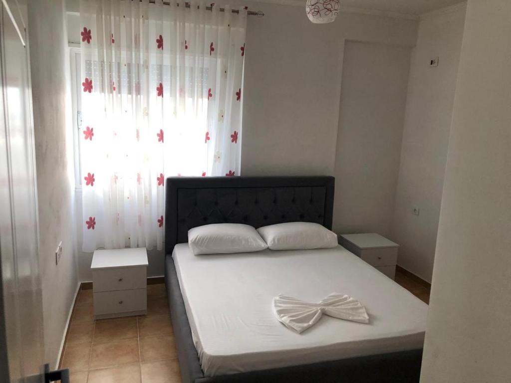 1 dormitorio con 1 cama con arco en Topi Apartments, en Vlorë