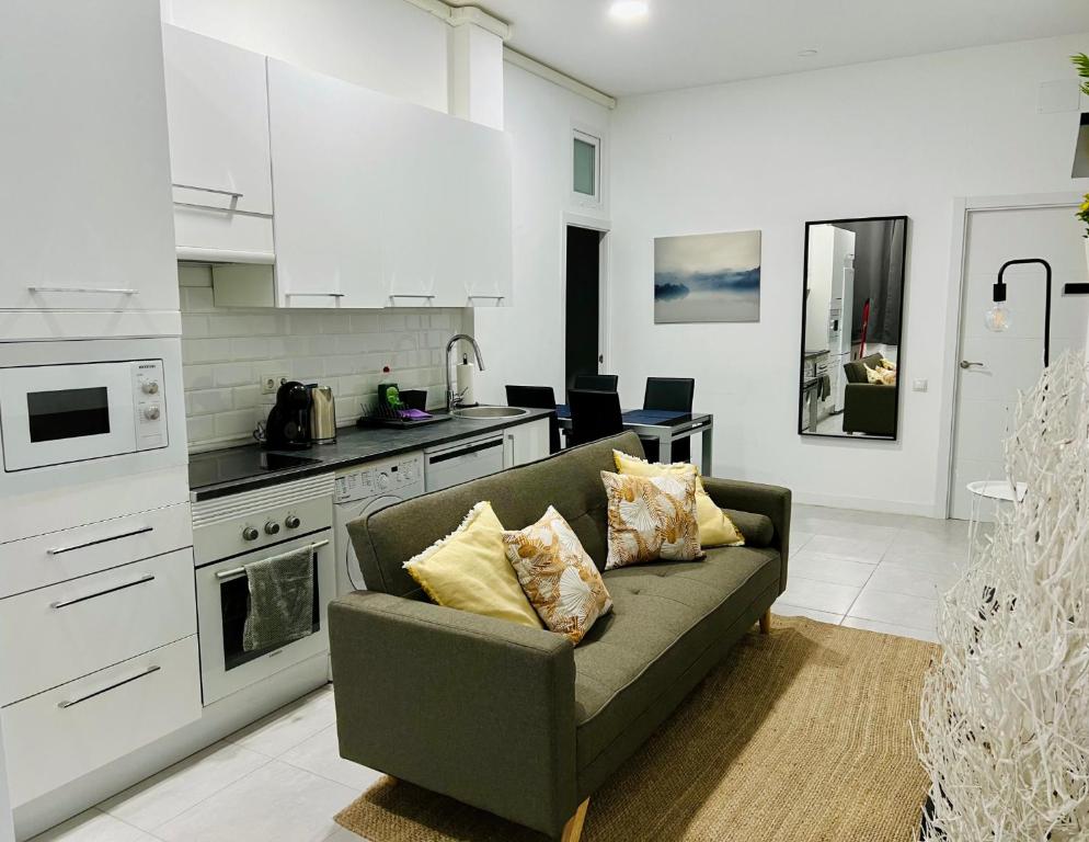 ein Wohnzimmer mit einem Sofa und einer Küche in der Unterkunft Casa Bandi in Madrid