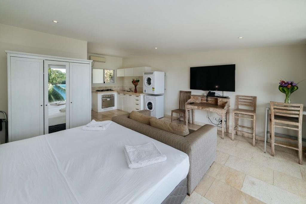 1 dormitorio con cama, sofá y TV en Mariner Apartments, en Port Vila