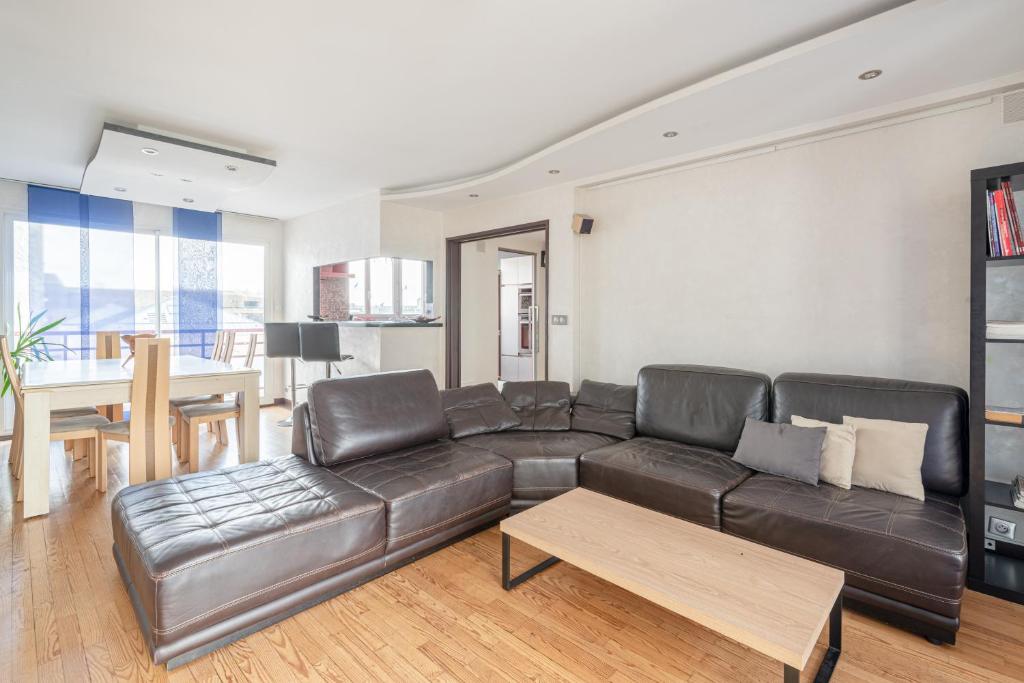 Una sala de estar con un sofá de cuero y una mesa. en "SUITE-HOME 44600" Apt d'exception 3 Etoiles, en Saint-Nazaire