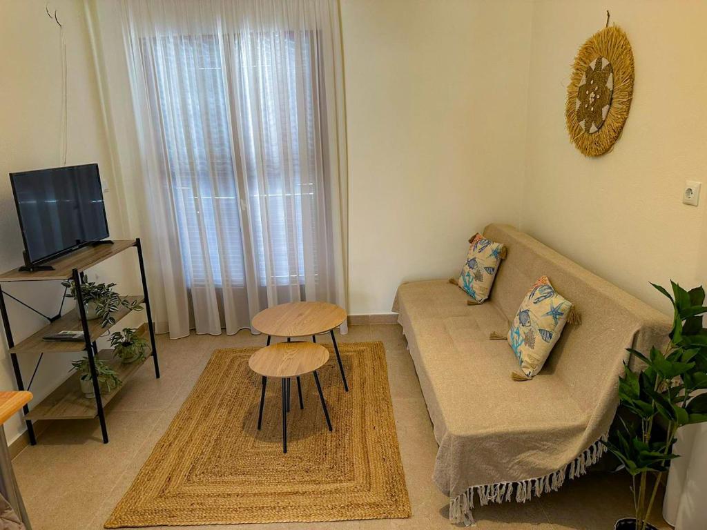 a living room with a couch and a table at Polichrono Cosy Summer House in Polykhrono