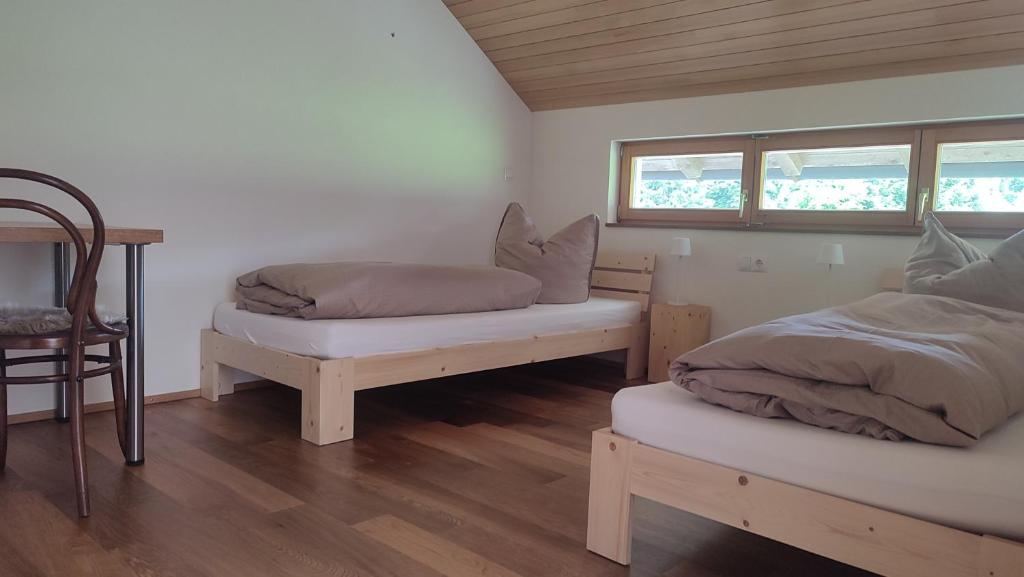 a bedroom with two twin beds and a chair at Landwohnung in Lingenau