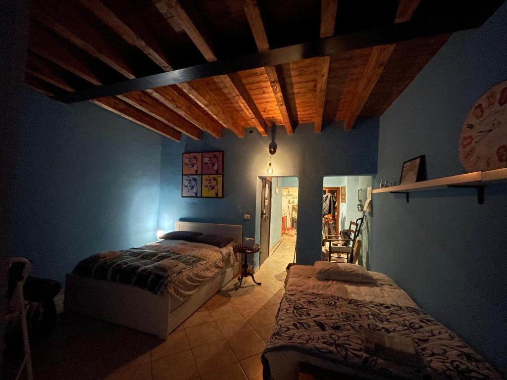 een slaapkamer met 2 bedden in een kamer met blauwe muren bij CASA AZZURRA, nel cuore di Genova in Genua