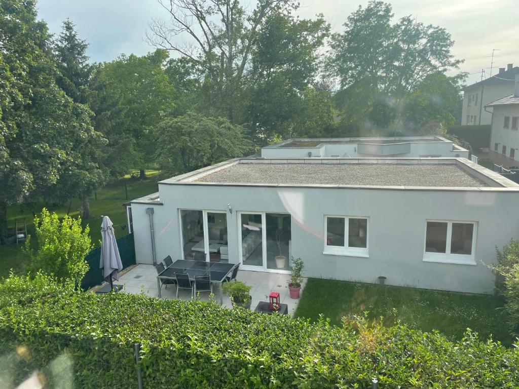 Blick auf ein weißes Haus mit einer Terrasse in der Unterkunft Villa plein pied in Lingolsheim