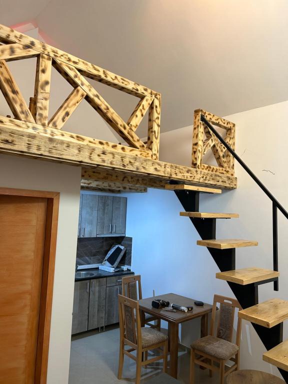 a wooden staircase in a room with a table and chairs at Zeleni Raj Apartmani in Vrdnik