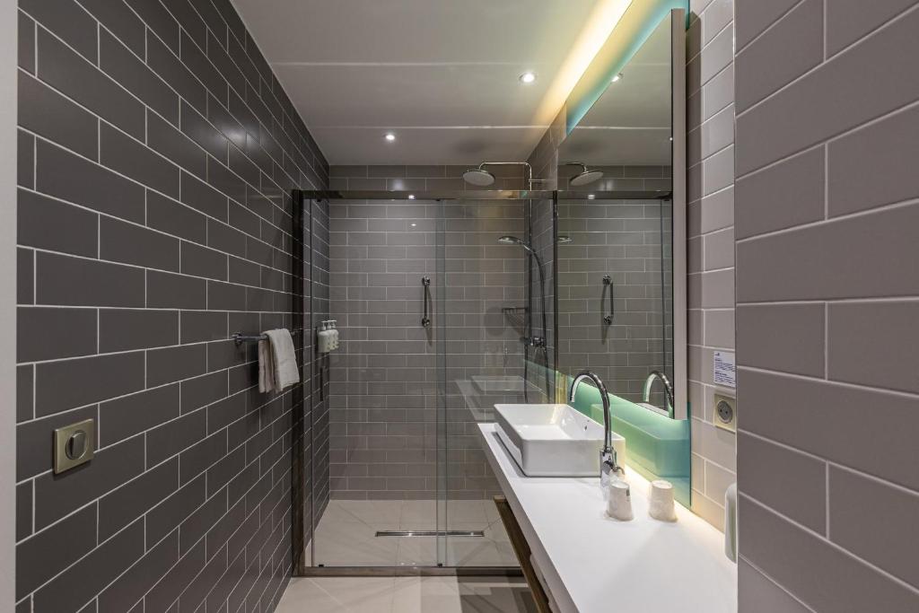 a bathroom with a sink and a shower at Holiday Inn Express Ajaccio by IHG in Ajaccio