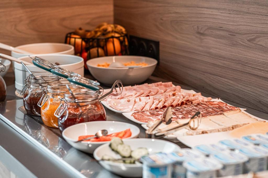 a buffet with meat and other foods on a table at Holiday Inn Express Ajaccio by IHG in Ajaccio