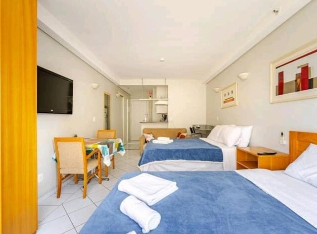 a hotel room with two beds and a television at flat Allianz Parque com estacionamento in São Paulo