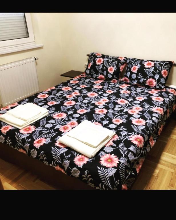 un letto in una camera con una coperta bianca e nera di Apartman Secujski a Sombor