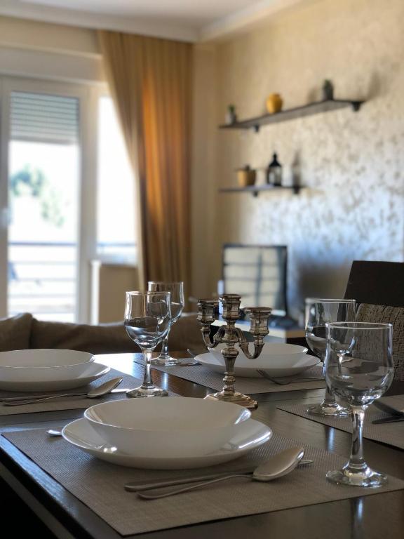 un tavolo con piatti e bicchieri da vino sopra di Apartman Secujski a Sombor